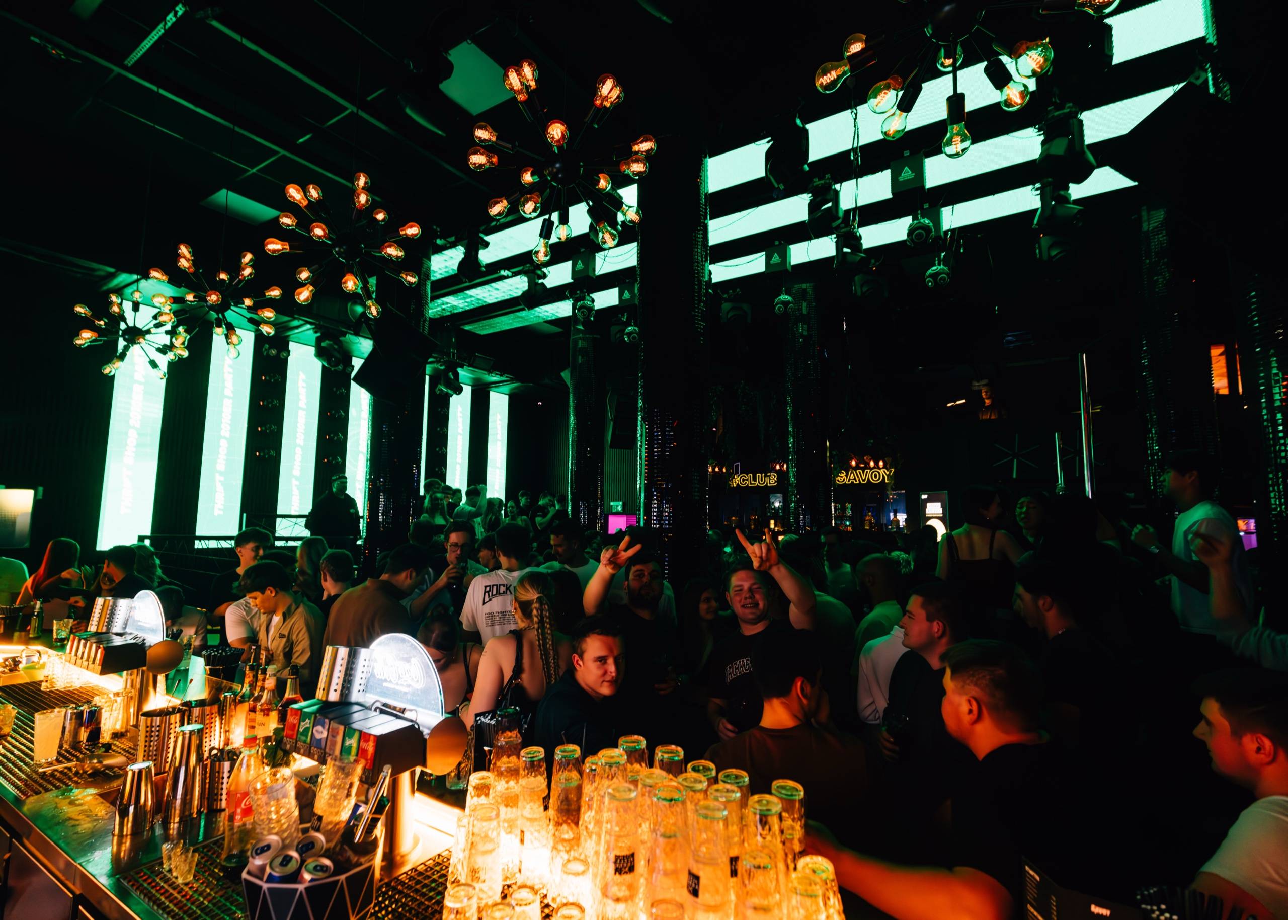 Die Bar im Club Savoy in grünem Licht, Gäste davor